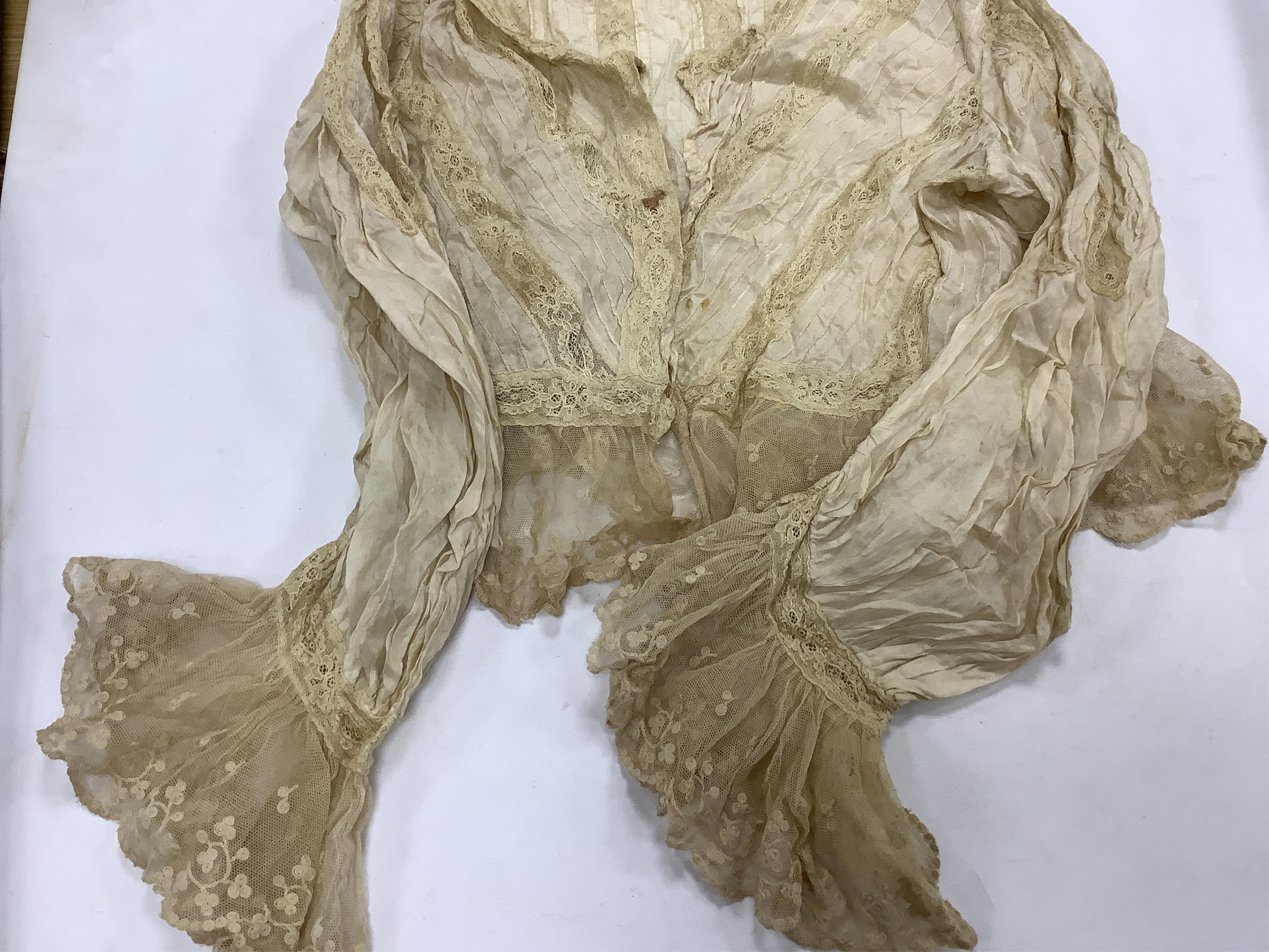 Two Edwardian blouses and three earlier lace camisoles, three black satin partly sewn skirts and later black velvet diamonte decorated evening coat. Condition - the coat, skirts and blouses need repair but are good for T
